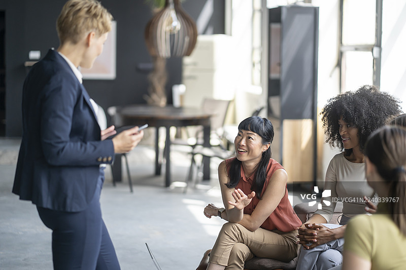 创意商业女性在现代办公室的休闲会议中倾听同事讲话图片素材