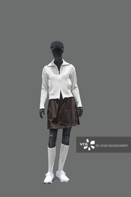 身穿白色绞花针织开衫和棕色裙子的模特图片素材