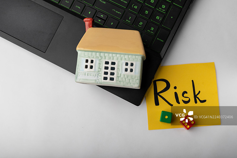 笔记本电脑背景上创意地呈现了家庭投资的风险图片素材