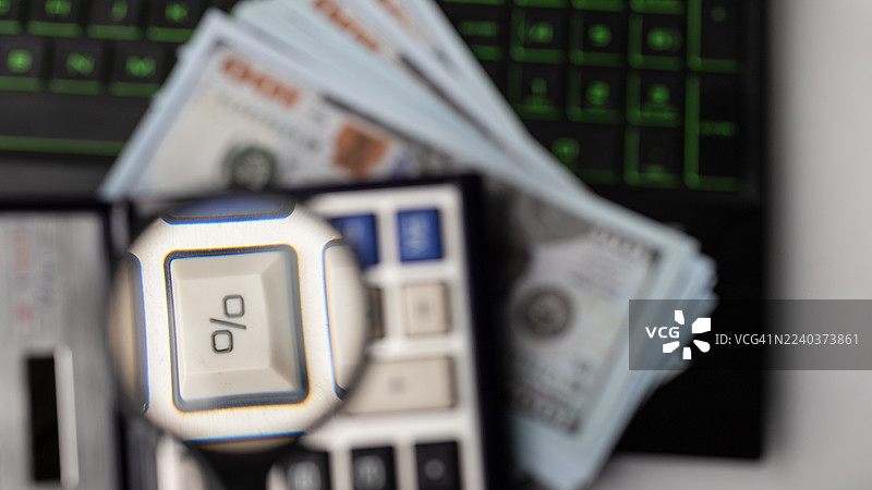 办公桌上展示的理财工具和技巧，包括计算器、现金和电脑图片素材