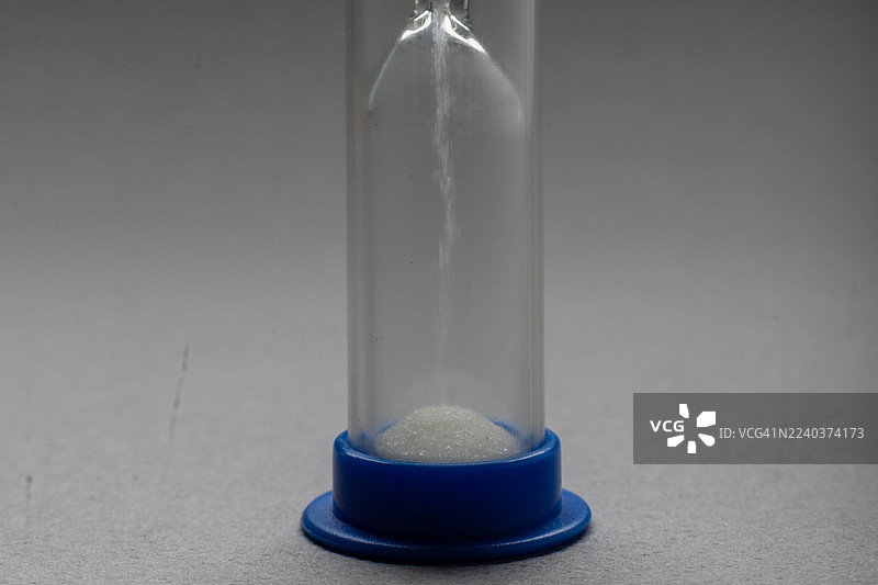 五颜六色的沙漏，在透明玻璃结构中，沙子缓缓流淌，测量着时间图片素材