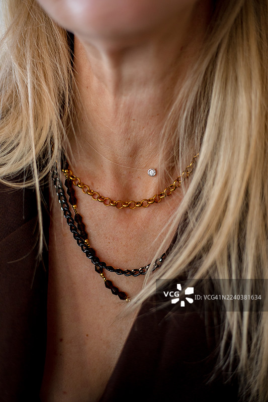 女人颈部优雅的层叠项链，带有小钻石吊坠的珠宝肖像图片素材