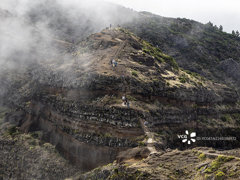 马德拉岛皮库·杜·阿里埃罗，山峰间的山间小径有阶梯，徒步者穿行于薄雾之中。图片素材