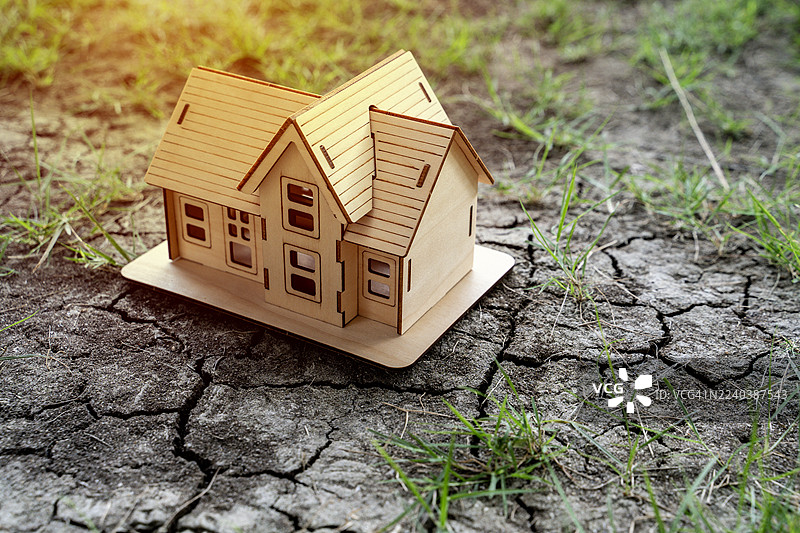 房屋置于干裂的土地上，象征着全球变暖和干旱图片素材