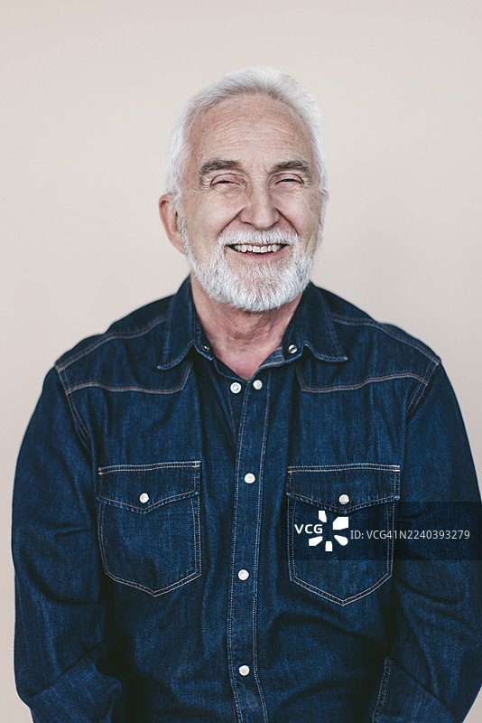 彩色背景前微笑的老年男性肖像图片素材