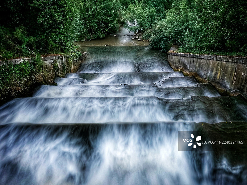 长曝光拍摄的人工瀑布，在混凝土台阶上形成如丝般的水流图片素材