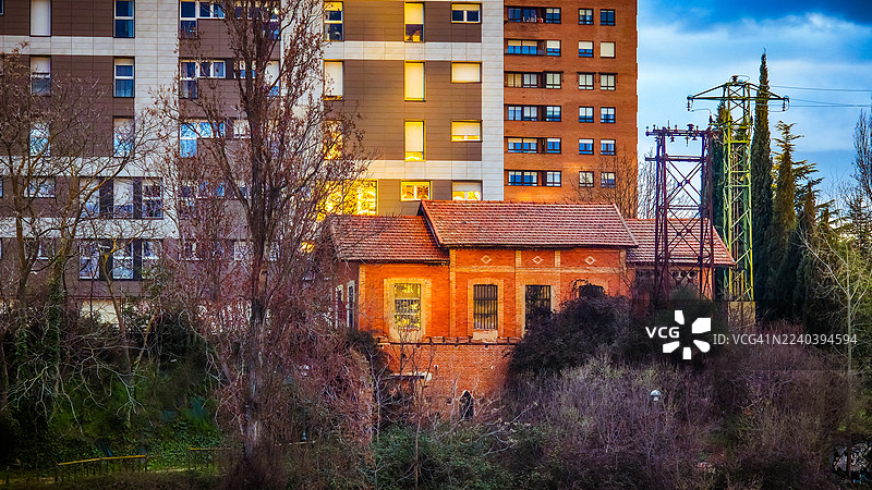 古老的红砖房屋与现代城市建筑形成鲜明对比图片素材