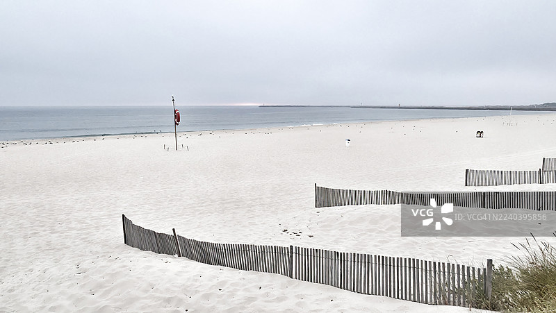 大西洋旁的白色沙滩上的救生圈和沙滩围栏图片素材