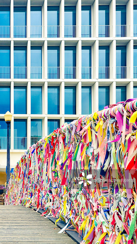 阳光明媚的日子里，背景是办公楼，彩色的丝带图片素材