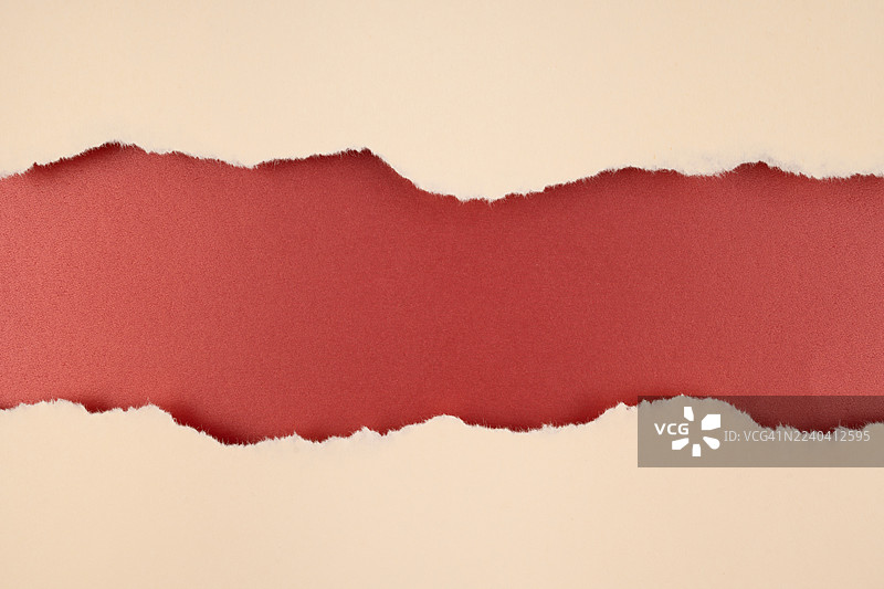红色背景上的棕色撕裂纸，用于您的文字或信息。图片素材
