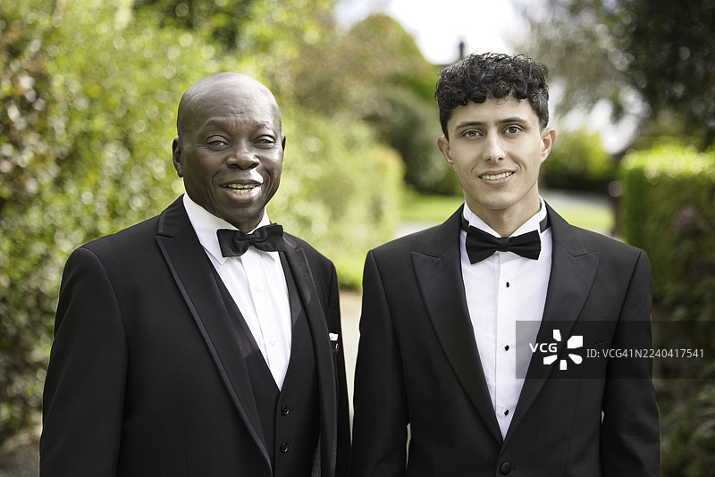 两位男士身着晚礼服，面带微笑图片素材
