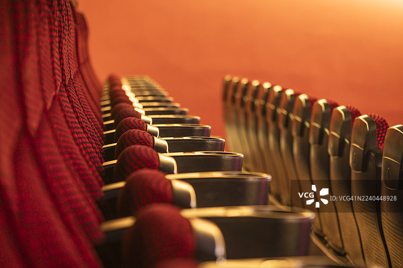 一排排红色的空电影院座位，形成重复的图案和抽象的构图，准备好迎接电影放映或剧院演示。 

## Translation Analysis:

- The original English text describes图片素材