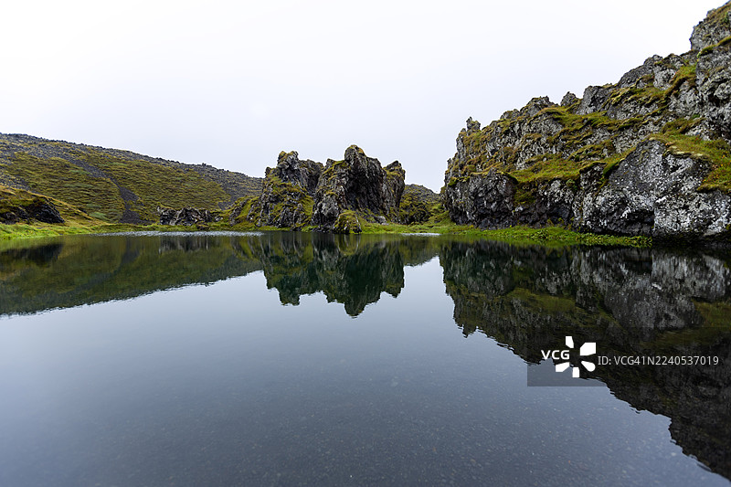 冰岛西部斯奈山半岛，迪尤帕洛冰川沙滩（Djúpalónssandur）的广角景观，可以看到火山岩层、斯奈菲德尔冰川（Snaefellsjokull）的峰顶以及废弃的渔船Epine GY7残骸。图片素材