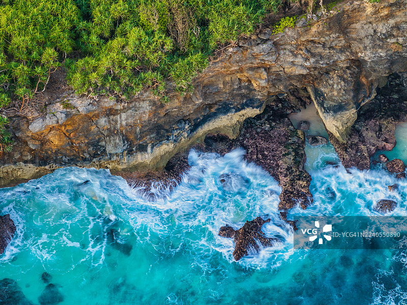 印尼巴厘岛努沙佩尼达岛断桥海滩的鸟瞰图。金色时段标志性的海岸岩石拱门、绿松石色的海水和壮观的悬崖,从空中捕捉到充满活力的热带风光。图片素材