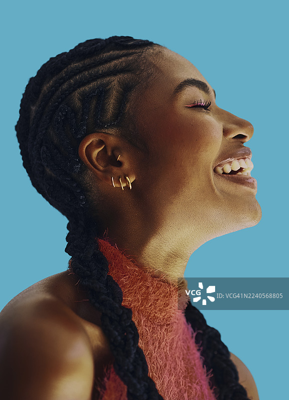 拥有辫子发的快乐黑人女性在极乐蓝背景前微笑图片素材
