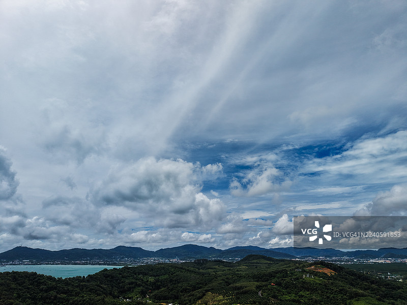 绿色热带山丘上方戏剧性的多云天空图片素材
