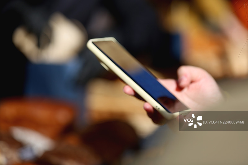 模糊的数字背景。顾客准备好在当地市场使用智能手机进行非接触式支付。图片素材