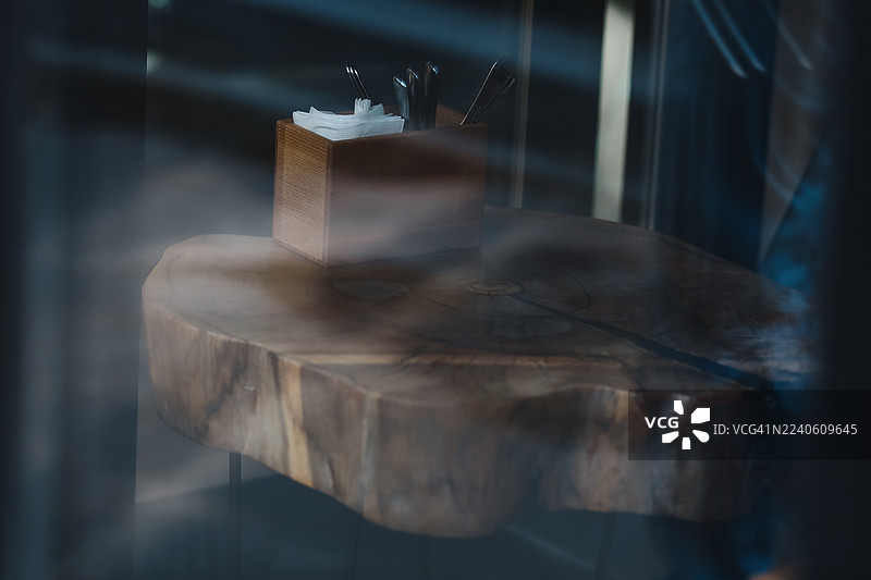 空旷的路边咖啡馆，配有木桌和优雅的装饰细节，透过商店的窗户望去图片素材