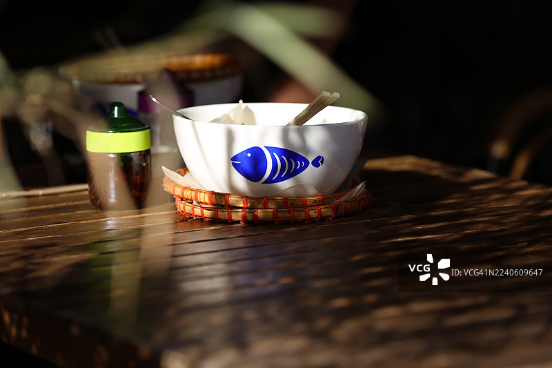 露天咖啡馆木桌上，午餐后空着的陶瓷碗盘图片素材