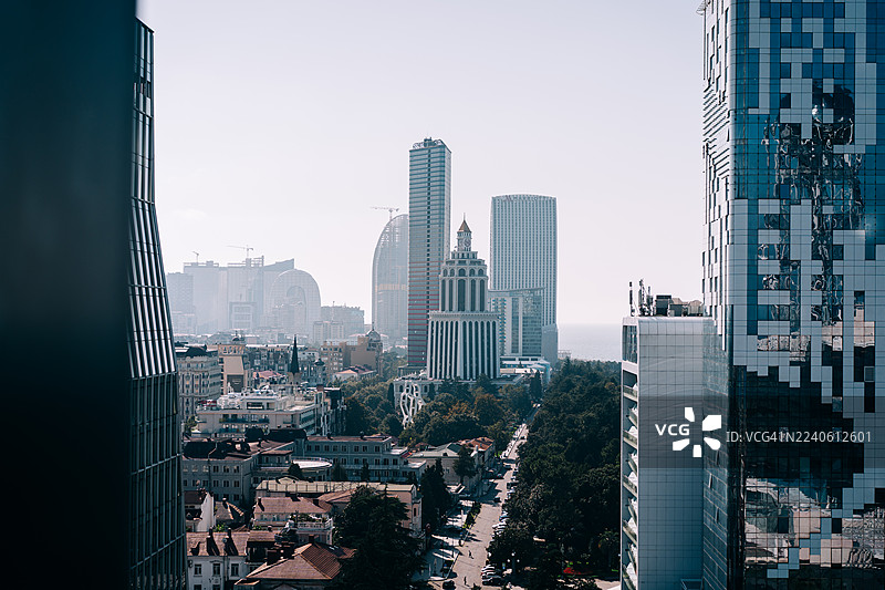 格鲁吉亚巴统市的现代城市天际线，拥有高耸的玻璃建筑和海岸地平线景观，在明亮的日光下图片素材