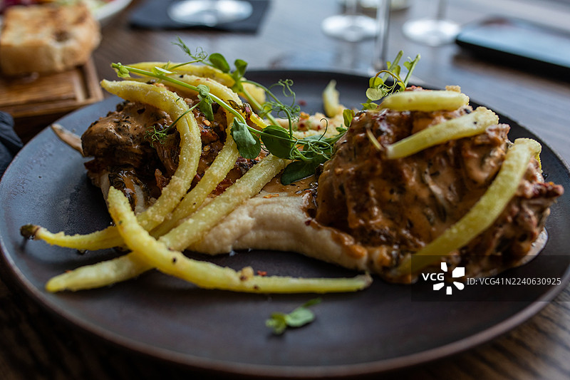 烤肉、薯条和新鲜微型蔬菜的美味菜肴，适合精致餐饮图片素材