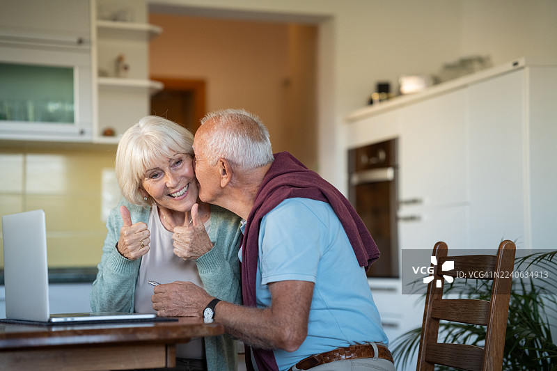 老年夫妇在笔记本电脑上查看旅游目的地图片素材