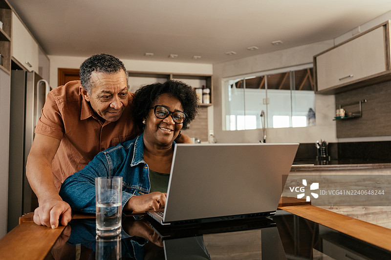 一对年迈的夫妇正在笔记本电脑上查看车票和住宿信息图片素材