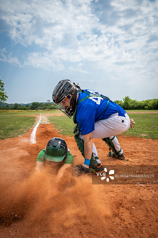 棒球运动员在比赛中将滑垒的跑垒员触杀出局图片素材