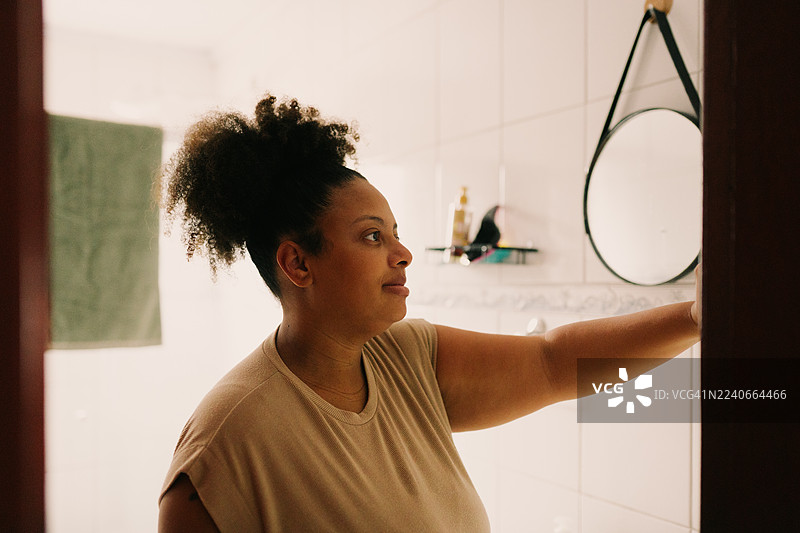 丰满的女性在浴室镜子前照镜子图片素材