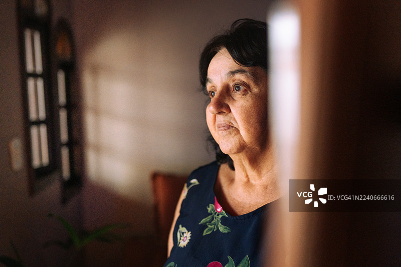 一位年长的胖女人肖像，看向窗外图片素材