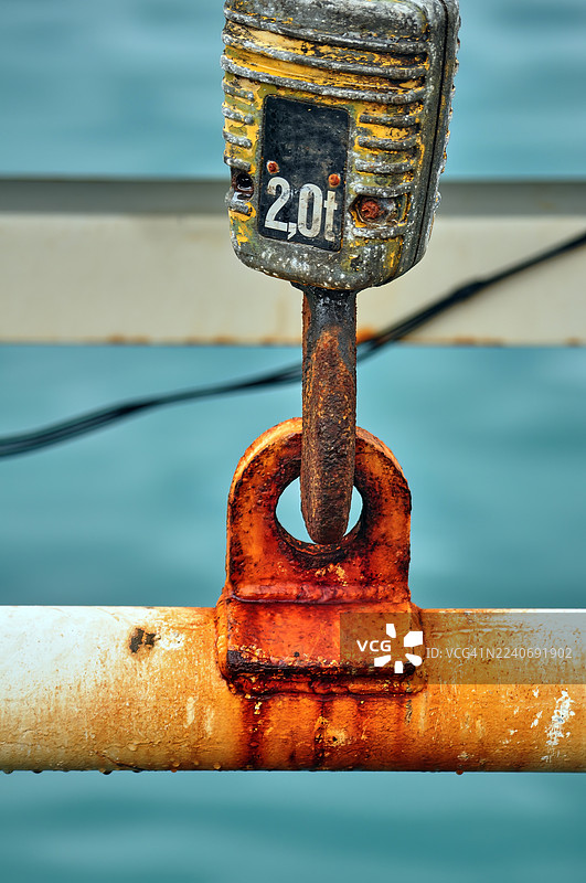 生锈的工业吊钩和“2.0吨”配重块的特写图片素材