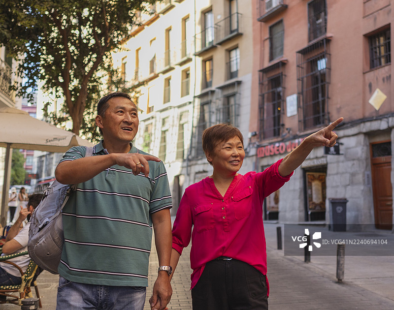 亚洲游客在欧洲度假期间，探索城市街道并用手指指点点。图片素材