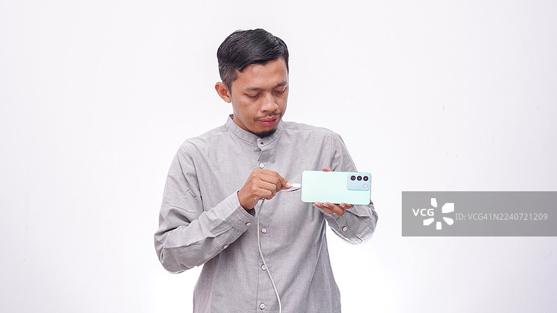 亚洲男人给智能手机充电图片素材