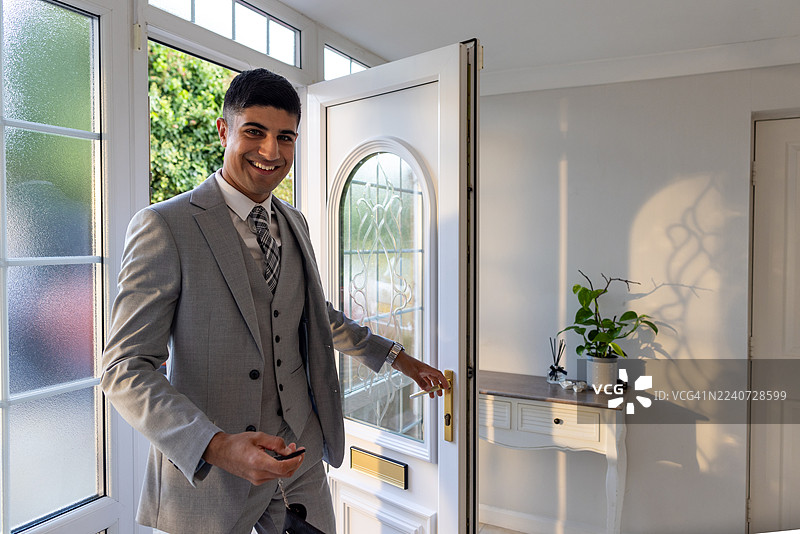 衣着考究的年轻男性成人正在进入他的家图片素材