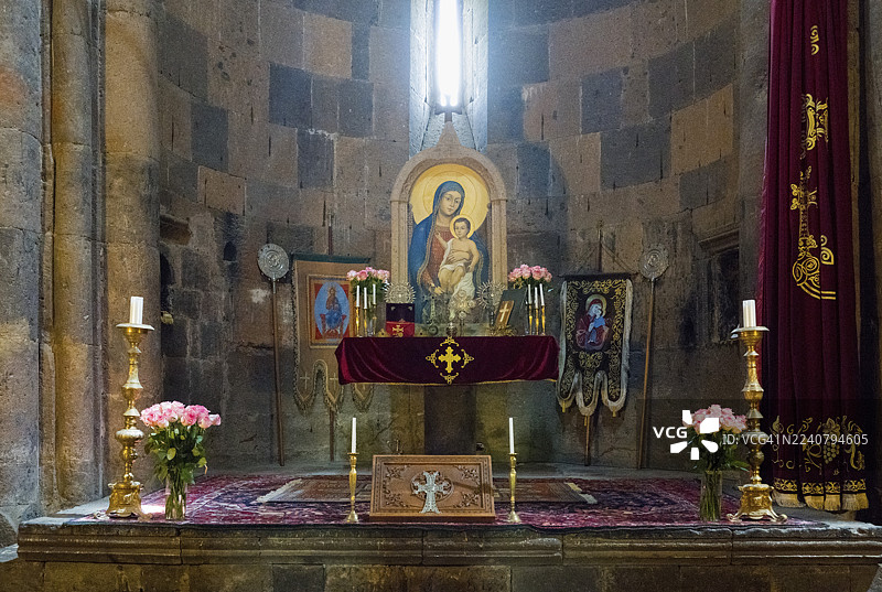 亚美尼亚阿拉加措特恩省萨赫莫萨万克修道院祈祷室内的教堂祭坛，摆放着宗教圣像、蜡烛和鲜花。图片素材