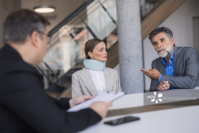 戴着颈托的女士与律师讨论人身伤害索赔图片素材