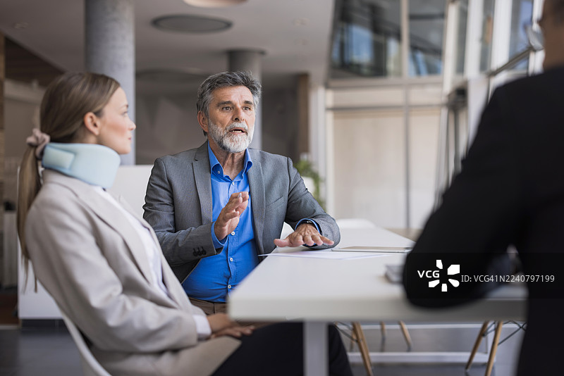 律师与戴着颈托的女士讨论个人伤害索赔图片素材