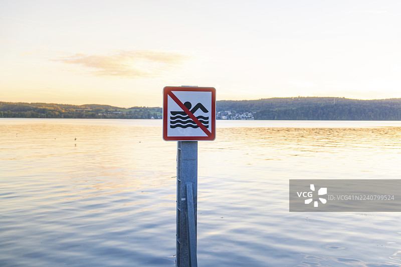 日落时分，德国康斯坦茨湖于伯林根平静水域上的非游泳者标识图片素材