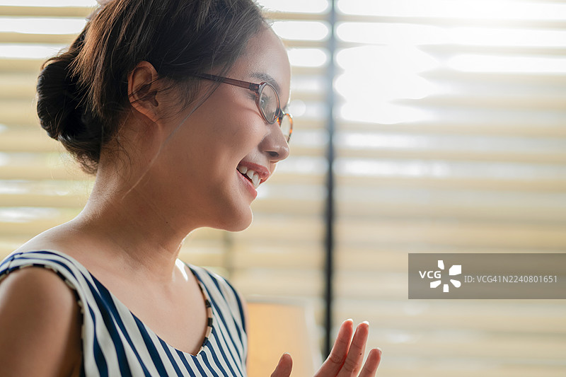 特写：女性的手在智能手机和平板电脑上与人工智能驱动的虚拟助手互动，显示屏上展示着智能技术，在家中利用无缝的数字智能管理任务。图片素材