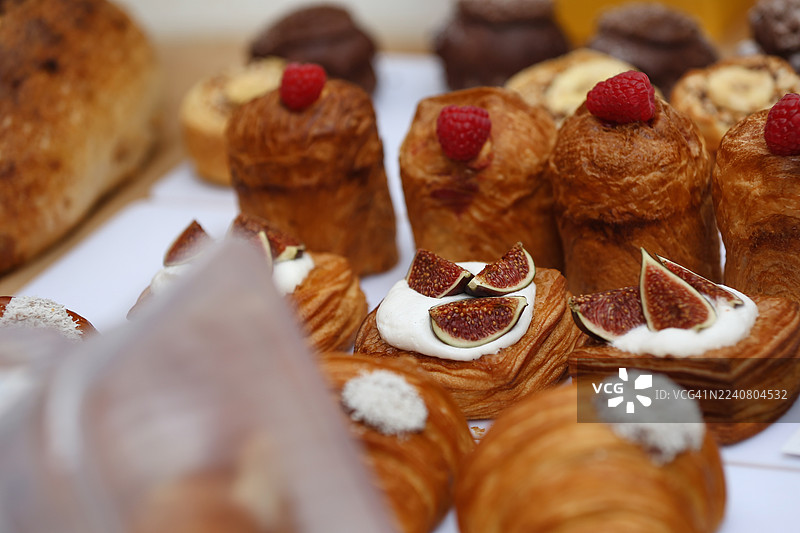 新鲜出炉的羊角面包，搭配覆盆子、无花果和打发奶油，在户外农贸市场上售卖图片素材