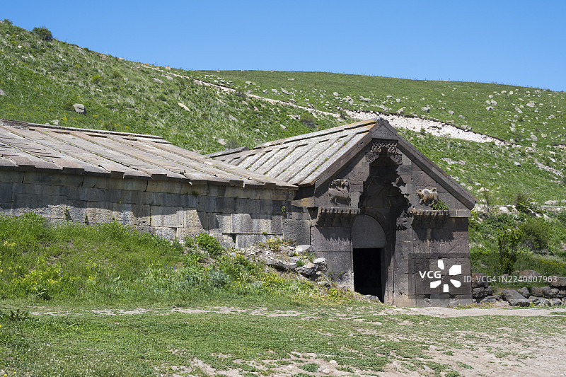 亚美尼亚瓦约茨佐尔省的瓦尔登尼斯山口或塞利姆山口，奥尔别良家族商队旅馆，塞利姆商队旅馆，背景为绿色山丘的乡村石头建筑图片素材