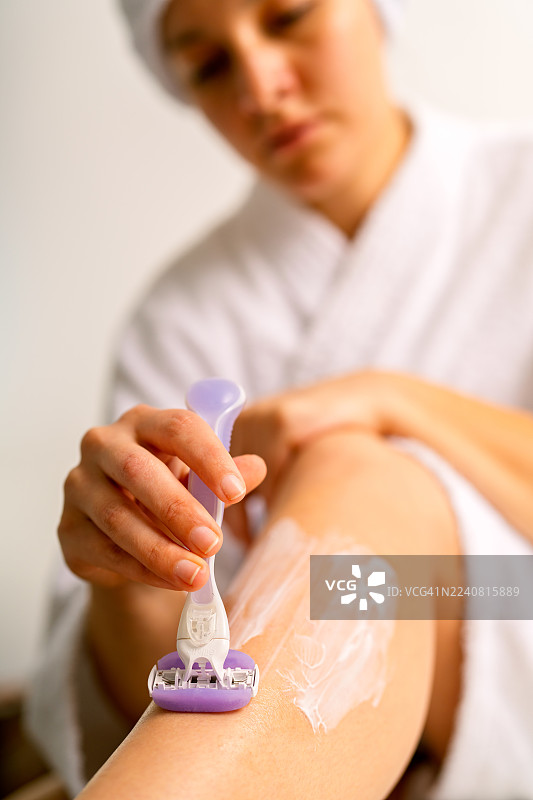 女人刮腿毛，保持个人卫生和美容习惯图片素材