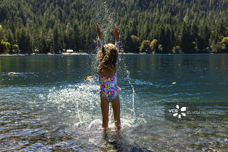 一位小女孩在华盛顿州月牙湖中嬉戏。图片素材