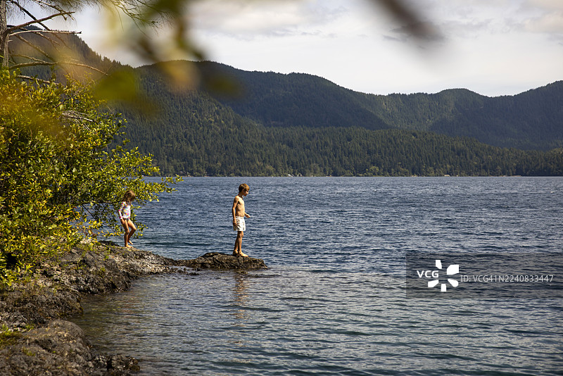 两个年幼的孩子在华盛顿州月亮湖的岸边玩耍。图片素材