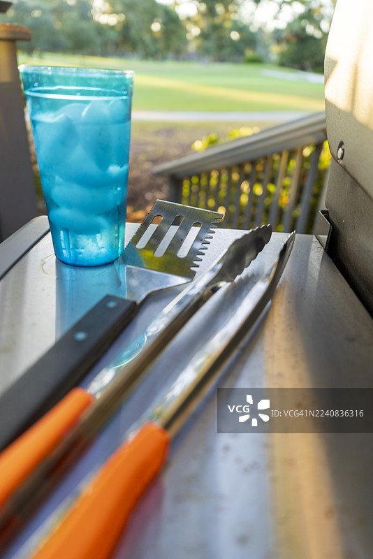 准备在烤架上烧烤——厨具和一杯冰水，焦点选择图片素材