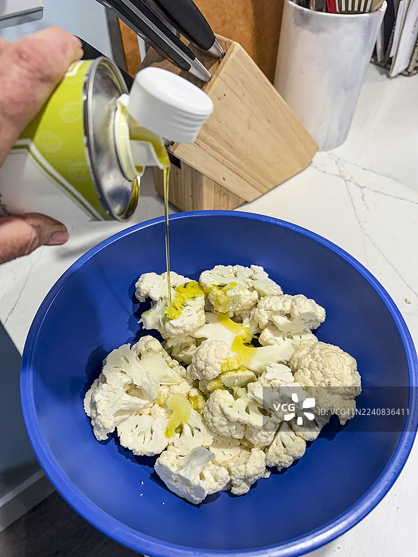 将花椰菜放在烤架上烹饪，在准备好的食物上淋上油，俯视镜头，系列照片之一图片素材