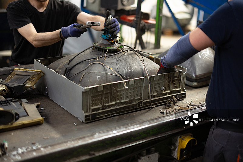 身穿防护装备的工人在分拣废旧电子产品图片素材