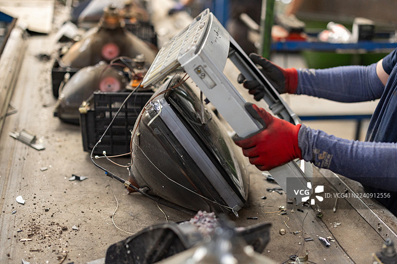 电子垃圾处理厂正在拆解旧电视屏幕图片素材