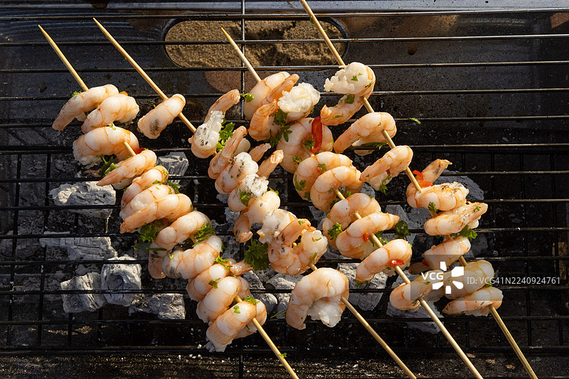 海滩上烤制的鲜虾串图片素材