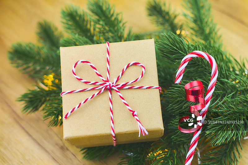节日礼品盒，旁边有红白丝带、拐杖糖和松枝图片素材
